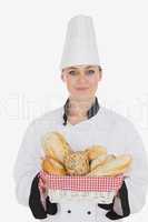 Female chef in uniform holding bread basket