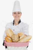 Happy young female chef with bread basket