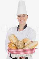 Young woman in chef uniform holding bread basket