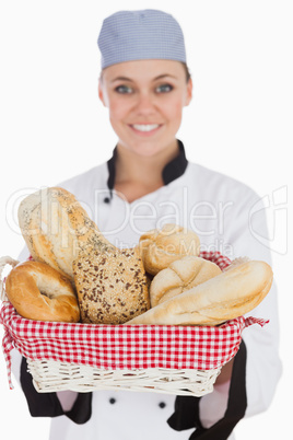 Female chef with fresh breads in basket