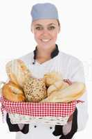 Female chef with fresh breads in basket