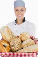 Female chef with various breads in basket