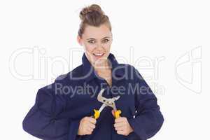 Playful female technician holding pliers wrench