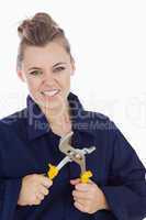 Female mechanic clenching teeth while holding pliers wrench