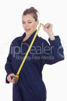 Female tecnician holding measuring tape as she winks