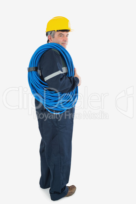 Portrait of mature repairman wearing hardhat with cable