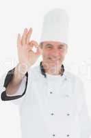 Happy male chef in uniform gesturing ok sign