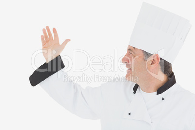 Happy mature chef in uniform gesturing