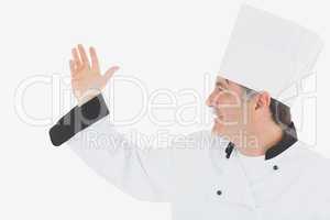 Happy mature chef in uniform gesturing