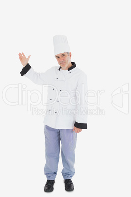 Mature chef displaying something on white