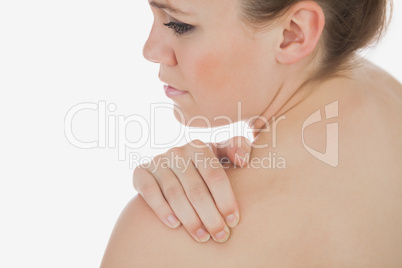 Topless woman massaging her shoulder