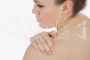 Topless woman massaging her shoulder
