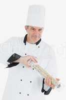 Confident chef using pepper mill