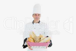 Male chef with fresh breads in basket