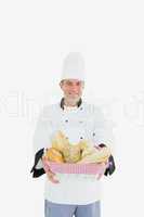 Male chef holding fresh breads in basket
