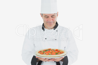 Mature chef holding pizza