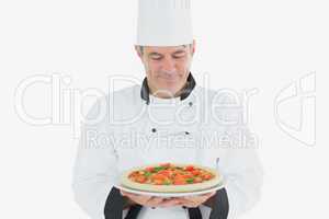 Mature chef holding pizza