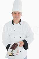 Male chef offering chocolate pastry