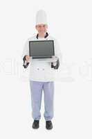 Happy male chef displaying laptop