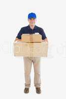 Delivery man carrying stack of cardboard packages