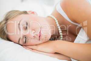 Sleeping cute woman with pearls necklace