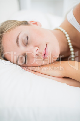 Close to a sleeping woman with pearls necklace