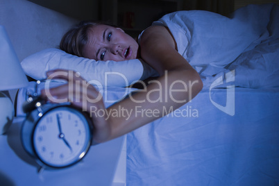 Awakening woman stopping her alarm clock