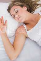 Peaceful woman sleeping in white bedroom