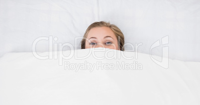 Woman hiding under the duvet