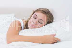 Cheerful woman sleeping in white bedroom