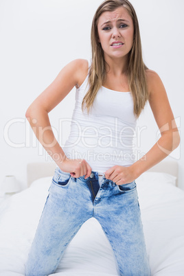 Discouraged woman trying to close her jeans