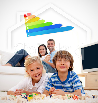 Two smiling children lying on a carpet with parents