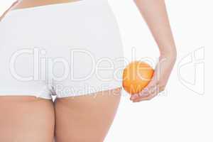 Woman in shorts with fresh orange
