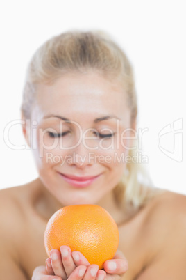 Happy woman smelling fresh orange