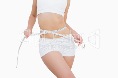 Woman measuring waist with a tape measure