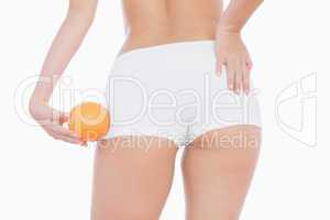 Woman in shorts holding orange