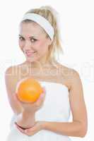 Happy young  woman holding orange