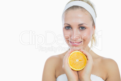 Happy woman holding slice of orange