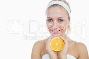 Happy woman holding slice of orange