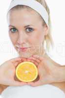 Attractive woman holding slice of orange