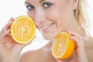 Beautiful woman holding slices of orange