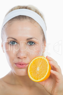 Portrait of woman holding orange slice