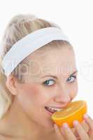 Woman biting slice of orange