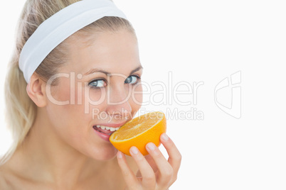 Woman biting slice of orange