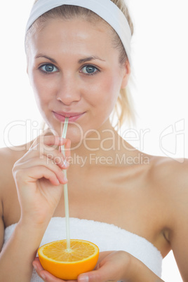 woman drinking from an orange with straw