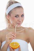 Woman drinking from a straw in an orange