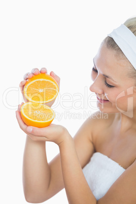 Happy woman holding slices of orange