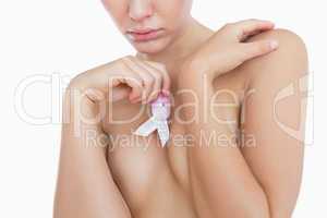 Naked woman holding breast cancer awareness ribbon