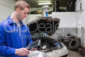 Mechanic with digital tablet at garage