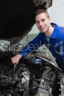 Young mechanic repairing car engine